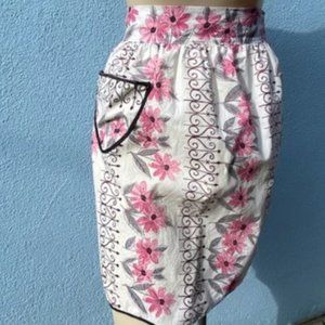 This precious apron was hand made in the 50's. with pink and gray flowers